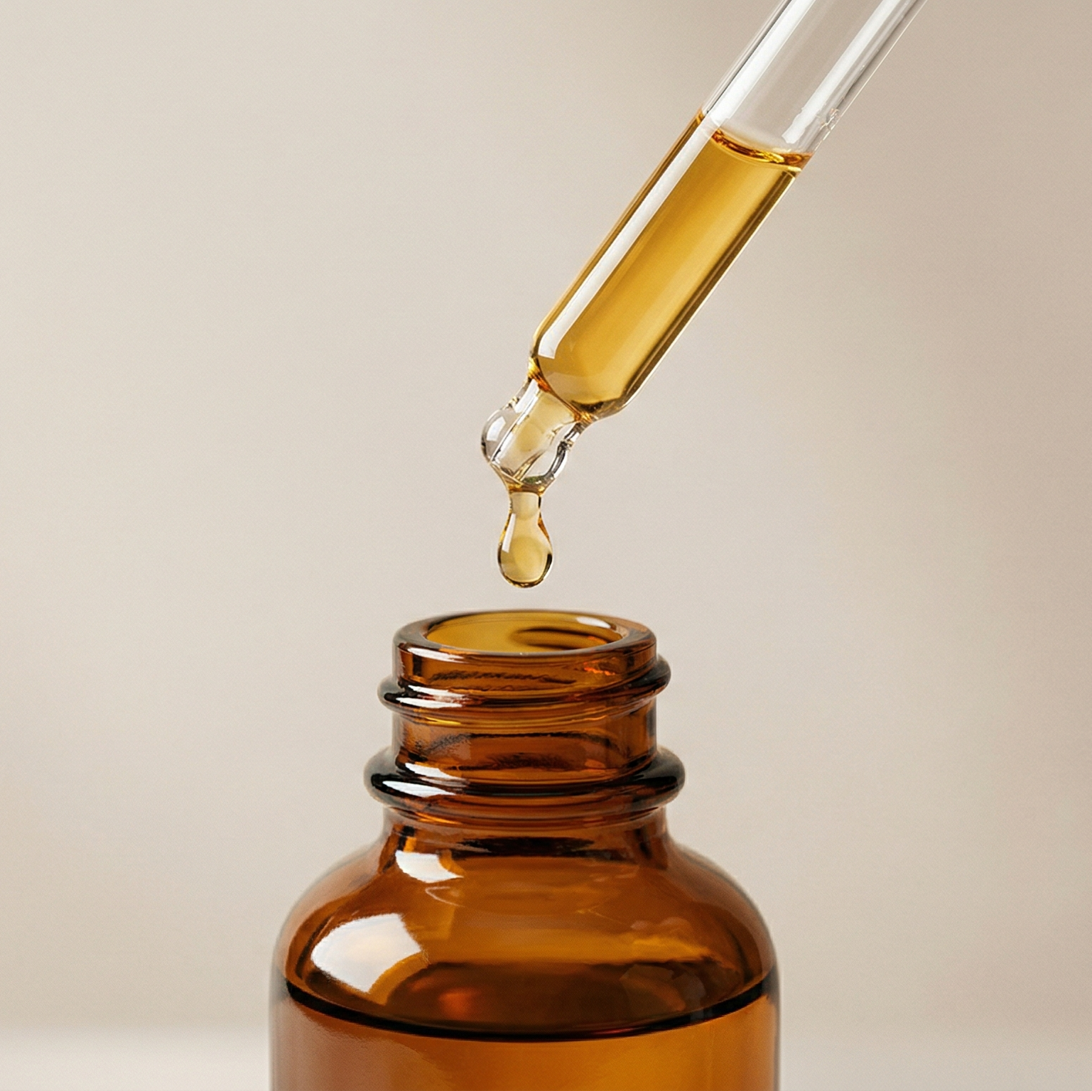 Brown glass bottle with dropper on a beige background